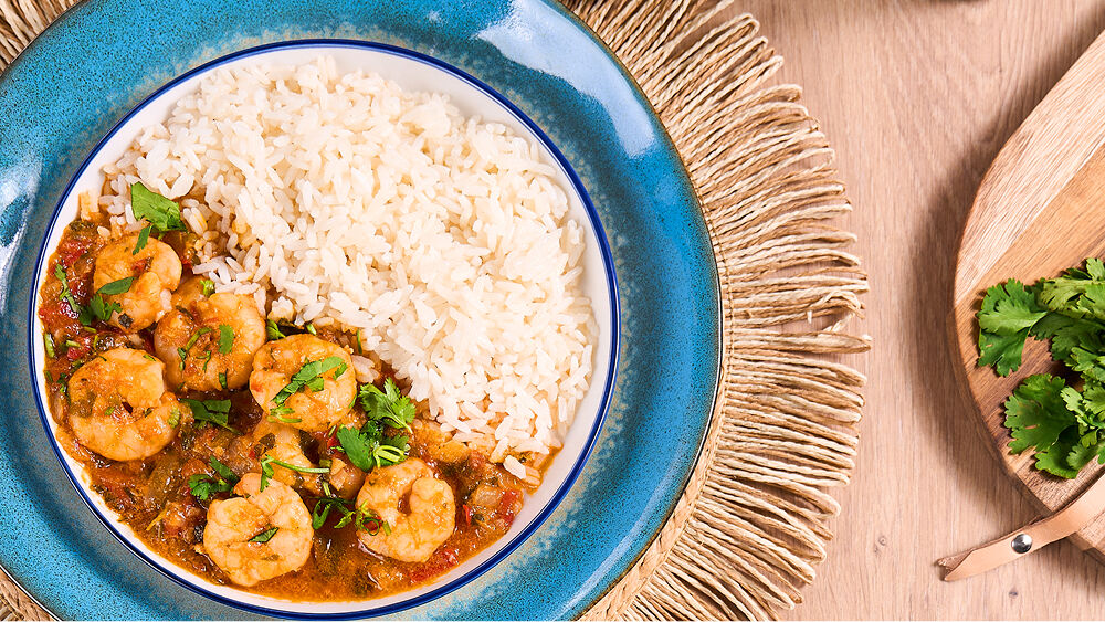 Fotografia de um prato azul com moqueca de camar&atilde;o